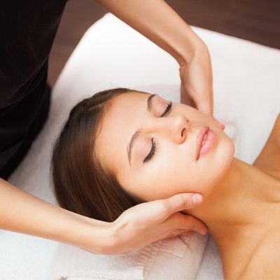 A brown-haired woman's relaxed face during a neck massage at the Treetops Resort Spa.