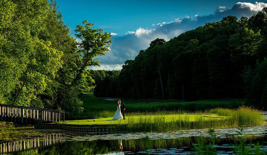 A bride and groom enjoy a quiet moment on a lush putting green at Treetops Resort in northern Michigan.