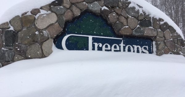 huge snowbank in front of stone Treetops sign